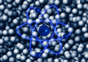 closeup of a number of atoms with an illustration showing an atom with its orbiting electrons